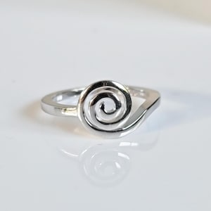 May include: A silver ring featuring a spiral design. The ring is simple and elegant.