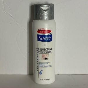 Op de afbeelding: Een witte fles Suave Humectant Conditioner met een zilveren dop. De fles heeft tekst die luidt: "ALSO TRY... NEW Professionals Styling Products", "Suave", "HUMECTANT CONDITIONER" en "NOURISHES HAIR AS WELL AS NEXXUS HUMECTRESS". Bevat 429 ml.