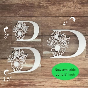 May include: Three white vinyl decals of the letter D with floral designs. The decals are available in sizes 3 inches, 3.5 inches, and 4 inches. "Now available up to 5" high" is written below the decals.