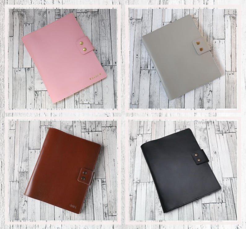 May include: Four leather folders in different colors: pink, gray, brown, and black. Each folder has a flap with two brass snaps.