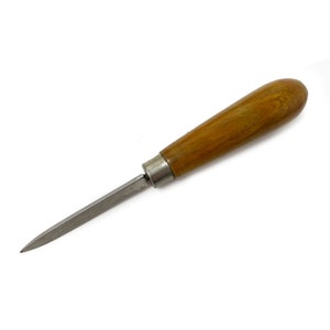 May include: A carving tool with a thin, sharp blade and a wooden handle. The tool is made of metal and wood and has a brown wooden handle.