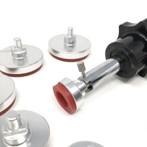 May include: A set of five silver-colored, round, rubber-tipped bases with a black and silver adjustable stand. The stand has a silver rod with a knob and a small silver lever.