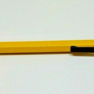May include: A yellow plastic tool with a black handle and a curved metal blade. The tool is used for deburring and trimming.