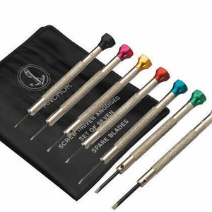 May include: A set of seven anodised spare blade screwdrivers with coloured tops, including black, pink, gold, red, teal, green, and silver. The screwdrivers are on a black case with the word "ANCHOR" and an anchor logo.