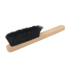 May include: A wooden-handled brush with black bristles. The brush is approximately 30 cm long.