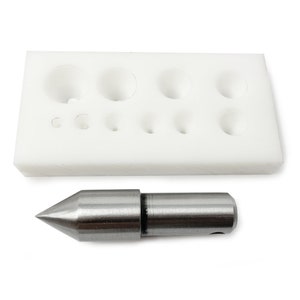May include: A white plastic mould with nine different sized round holes for making jewellery. A silver metal tool with a pointed tip is also included.