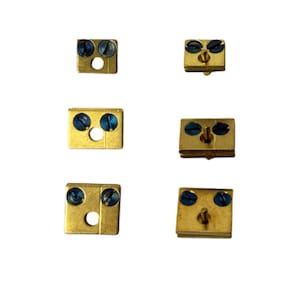 May include: Six gold-coloured metal electrical connectors with blue screws. The connectors have two screw terminals and a centre hole.