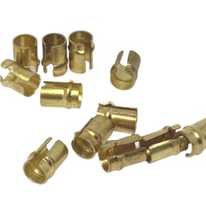 May include: A group of 10 gold-coloured metal electrical connectors. The connectors are designed to be crimped onto wires.