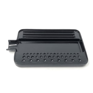 May include: Black plastic tray with a raised lip and a series of small, round indentations on the bottom. The tray has a long, narrow channel running along the top.