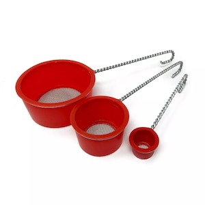 May include: Three red plastic strainers with wire handles. The strainers are different sizes and have a fine mesh screen.