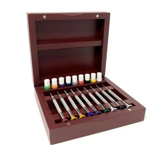 May include: A set of 10 precision screwdrivers in a wooden box with a red finish. The screwdrivers are arranged in a row and have different coloured handles. The box has a hinged lid and a small shelf inside.