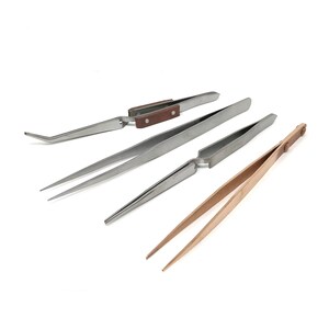 Peut inclure: Quatre paires de pinces à épiler sont présentées sur fond blanc. Les pinces sont en métal et en bois. Une paire a une pointe incurvée, les autres ont des pointes droites. Les manches sont bruns.