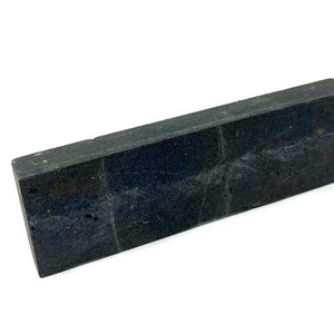 May include: A dark grey rectangular sharpening steel with a rough textured surface.