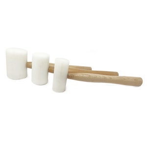May include: Three white rubber mallets with wooden handles. The mallets are different sizes, with the largest mallet having a handle that is about 45 cm long.