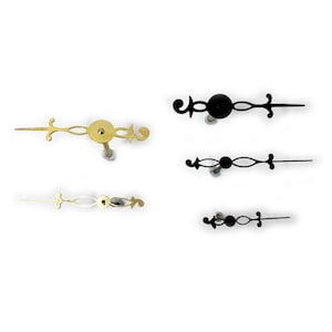 May include: Four clock hands, two gold and two black, with intricate designs. The hands are for use in a clock mechanism.
