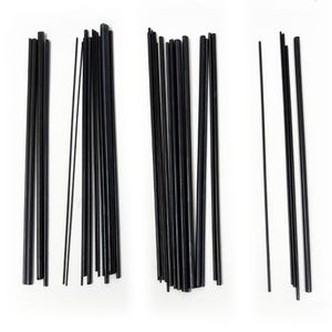 May include: Several bundles of black, thin rods of different lengths are displayed against a white backdrop. The rods, likely made of plastic or metal, have a smooth finish. The lighting is bright, emphasizing the shape and texture of the rods. Measurements are not available.