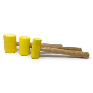 May include: Three yellow rubber mallets with wooden handles. The mallets are of different sizes.