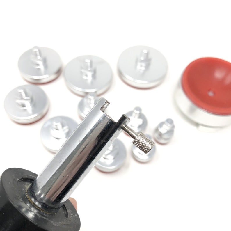 May include: A set of silver-toned suction cups with a black handle and a silver-toned adjustment knob. The suction cups are used for lifting and moving glass.