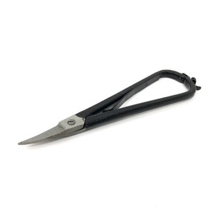 May include: Black handled shears with a long, curved, silver blade. The shears are designed for cutting fabric.