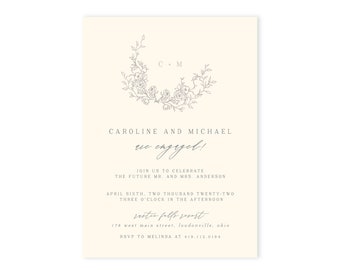 May include: A cream-colored wedding announcement card with a floral wreath design in gray. The text reads "Caroline and Michael are engaged!" and includes the date, time, and location of the celebration. RSVP information is also included.