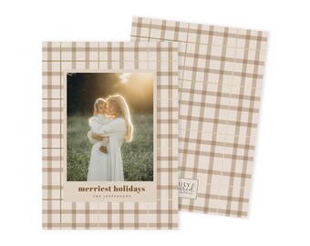 May include: Holiday card with a family photo. The card has a beige plaid pattern with gold accents. The photo features a woman holding a child. The text on the card reads "merriest holidays" and "the Jeffersons".