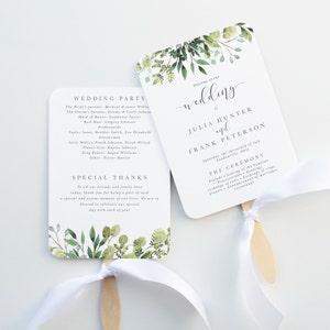 May include: Two white wedding fans with wooden handles and white ribbon ties. One fan features the text "Wedding Party" and "Special Thanks". The other fan says "Welcome to the wedding of Julia Hunter and Frank Peterson". Both fans have green floral accents.