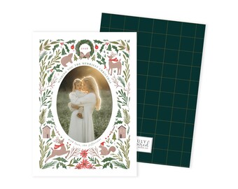 May include: Christmas card featuring a family photo within an oval frame. The card is decorated with festive illustrations of a bear, deer, squirrel, and houses, surrounded by greenery. The text reads "Wishing you the merriest Christmas" and "with love, the Jeffersons."