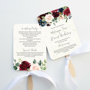 May include: Wedding ceremony program fan with a floral design in shades of burgundy, pink, and blue. The fan features the names "Melizza Sue & David Nicholas" and the wedding date and location. The back of the fan includes the wedding party and special thanks.