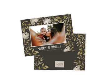 May include: A holiday greeting card with a photo of a mother and child. The card has a dark background with gold and white floral and leaf accents. The text "MERRY & BRIGHT" is displayed on the card.