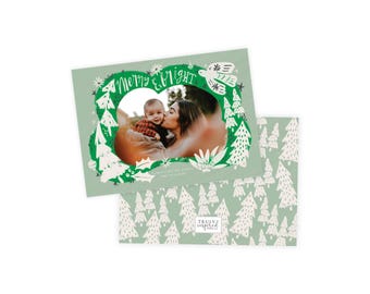 May include: A holiday greeting card with a photo of a baby and a person kissing the baby. The card has a green border with the words "merry & bright" and a design of trees and other holiday elements. The back of the card has a pattern of white trees on a green background.