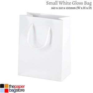 May include: A white gloss paper gift bag with white rope handles. The bag measures 6.3 inches wide by 8.3 inches high by 4 inches deep.