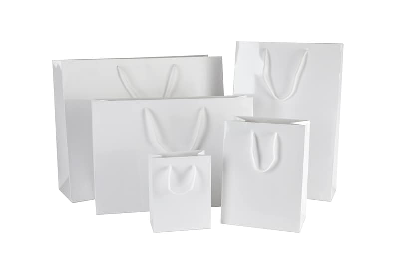 May include: Five white paper gift bags of varying sizes with white rope handles.
