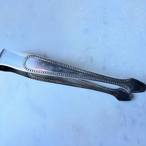 Old silver metal sugar tongs