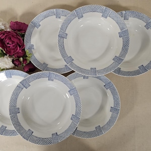 May include: Set of six white ceramic soup bowls with a blue and white geometric pattern. The bowls are stacked on top of each other.