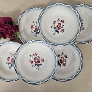 Puede incluir: Juego de seis cuencos de sopa de cerámica blanca con diseños florales azules y rojos. Los cuencos tienen un borde festoneado y un borde azul.