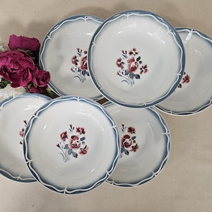 Puede incluir: Juego de seis cuencos de sopa de cerámica blanca con diseños florales azules y rojos. Los cuencos tienen un borde festoneado y un borde azul.