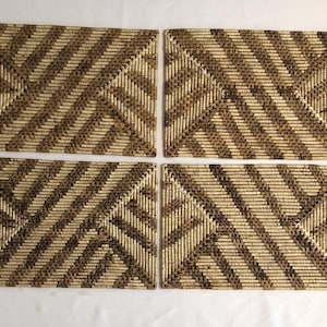 May include: Set of four woven placemats with a geometric pattern in brown and beige.