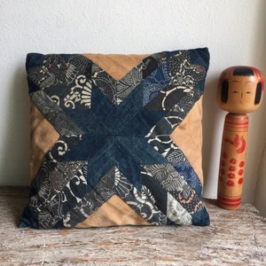 May include: A blue and brown patchwork pillow with a star design. The pillow is made of different fabrics and has a rustic look.