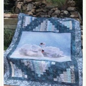 Peut inclure: Une courtepointe blanche avec un motif géométrique bleu et gris. La courtepointe présente une photo de deux cygnes blancs sur un fond bleu.