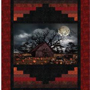 May include: A framed quilt with a central image of a spooky barn scene under a full moon. The quilt features a black and red geometric border, with a dark, moody color palette.
