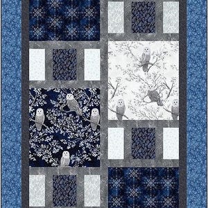May include: A quilt block with a blue and white snowflake pattern, a white background with branches and owls, and a gray border. The quilt block is made up of nine squares.