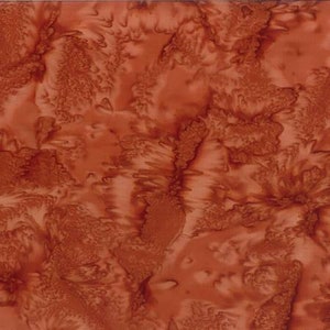 May include: A rust-colored fabric with a swirled pattern. The fabric has a subtle sheen and a soft, flowing texture.
