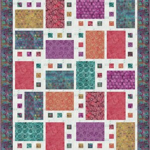 Op de afbeelding: Een patchworkdeken met een witte achtergrond en een verscheidenheid aan gekleurde vierkanten. De vierkanten hebben verschillende patronen, waaronder bloemen, geometrische en abstracte ontwerpen. De deken is omgeven door een rand van teal en paars.