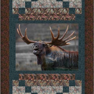 May include: A quilt featuring a brown moose with a forest scene superimposed on its body. The moose is standing in a forest setting. The quilt has a dark blue border with a white and brown patterned border.