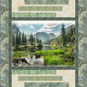 May include: A framed print of a scenic landscape featuring a lake surrounded by green trees and mountains in the background. The frame has a rustic, wood-like design with a light beige background and green accents.