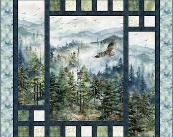 May include: A square quilt featuring a watercolor painting of a forest scene with an eagle in flight. The quilt has a dark blue border with square accents and a patterned edge in shades of blue and green. The forest scene includes tall evergreen trees and misty mountains.