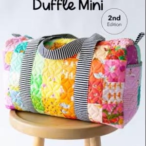 May include: A colorful patchwork duffle bag with a striped handle and accents. The bag features a variety of fabric patterns in shades of pink, yellow, green, and orange. The text "Patchwork Duffle Mini" is displayed at the top.
