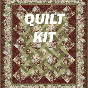 May include: A floral quilt kit with a burgundy and olive green lattice design. The quilt features a repeating pattern of floral bouquets in shades of pink, blue, and cream. The border is adorned with a floral garland, and the words "QUILT KIT" are displayed.