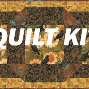 May include: A quilt kit featuring a sunflower and crow design. The central panel displays sunflowers and black crows, framed by a decorative border with the words "QUILT KIT" in large white letters.
