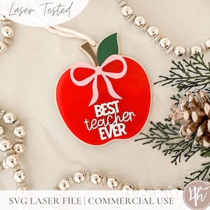 May include: Red apple-shaped ornament with a green stem and a pink bow. The ornament has the text "BEST teacher EVER" on it.
